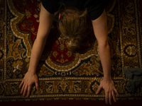 A woman is seen doing yoga exercises with YouTube trainer on a television in her living room in Warsaw, Poland on 23 March, 2024. (