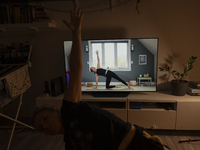 A woman is seen doing yoga exercises with YouTube trainer on a television in her living room in Warsaw, Poland on 23 March, 2024. (