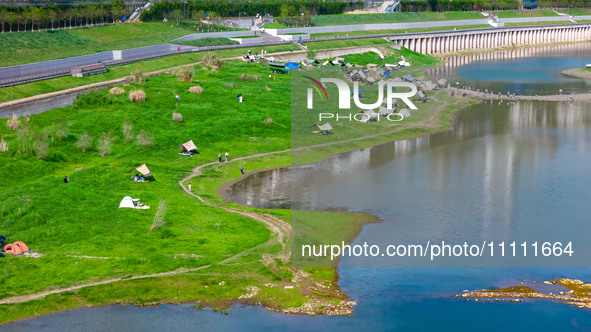 Tourists are camping and playing on the river beach as the water levels of the Yangtze and Jialing rivers continue to fall in Chongqing, Chi...