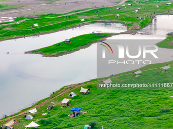 Tourists are camping and playing on the river beach as the water levels of the Yangtze and Jialing rivers continue to fall in Chongqing, Chi...