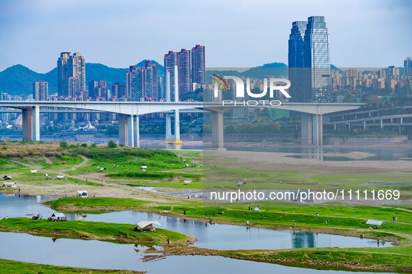 Tourists are camping and playing on the river beach as the water levels of the Yangtze and Jialing rivers continue to fall in Chongqing, Chi...