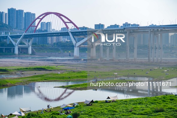 Tourists are camping and playing on the river beach as the water levels of the Yangtze and Jialing rivers continue to fall in Chongqing, Chi...