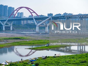 Tourists are camping and playing on the river beach as the water levels of the Yangtze and Jialing rivers continue to fall in Chongqing, Chi...