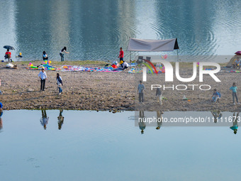 Tourists are camping and playing on the river beach as the water levels of the Yangtze and Jialing rivers continue to fall in Chongqing, Chi...