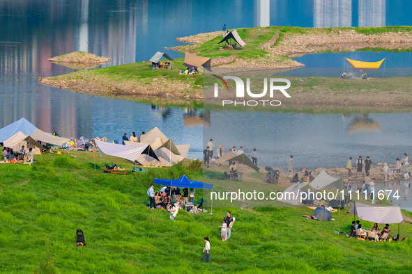 Tourists are camping and playing on the river beach as the water levels of the Yangtze and Jialing rivers continue to fall in Chongqing, Chi...