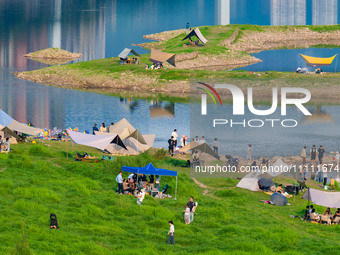 Tourists are camping and playing on the river beach as the water levels of the Yangtze and Jialing rivers continue to fall in Chongqing, Chi...