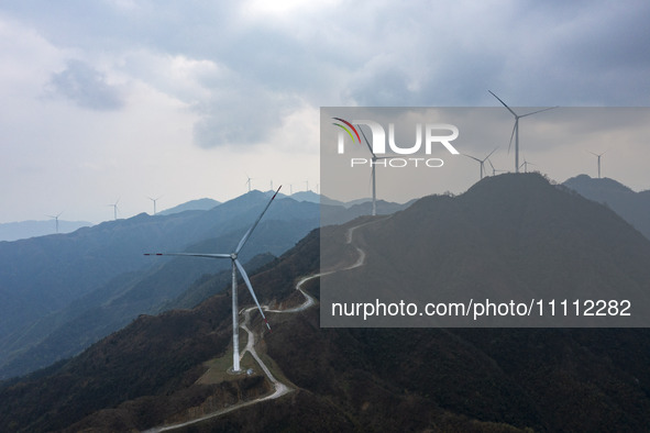 Wind turbines are standing above the rolling green mountains at the Xiutang Township wind farm in Congjiang County, Guizhou Province, China,...