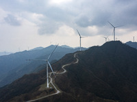 Wind turbines are standing above the rolling green mountains at the Xiutang Township wind farm in Congjiang County, Guizhou Province, China,...