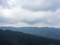 Wind turbines are standing above the rolling green mountains at the Xiutang Township wind farm in Congjiang County, Guizhou Province, China,...