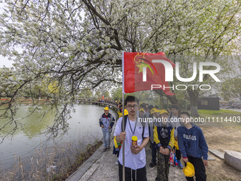 Primary school students are participating in a research activity amid blooming flowers at the Hongze Lake Wetland scenic spot in Sihong Coun...