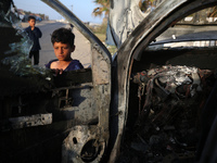 Palestinians are standing next to a vehicle in Deir Al-Balah, in the central Gaza Strip, on April 2, 2024, where employees from the World Ce...