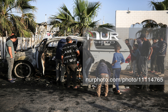 Palestinians are standing next to a vehicle in Deir Al-Balah, in the central Gaza Strip, on April 2, 2024, where employees from the World Ce...