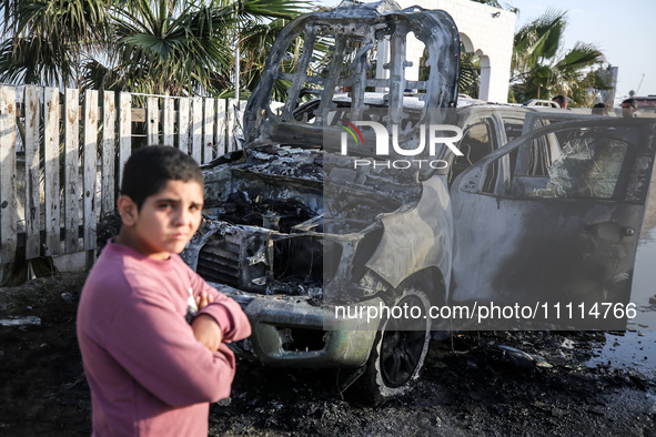 Palestinians are standing next to a vehicle in Deir Al-Balah, in the central Gaza Strip, on April 2, 2024, where employees from the World Ce...