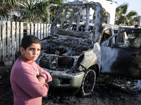 Palestinians are standing next to a vehicle in Deir Al-Balah, in the central Gaza Strip, on April 2, 2024, where employees from the World Ce...