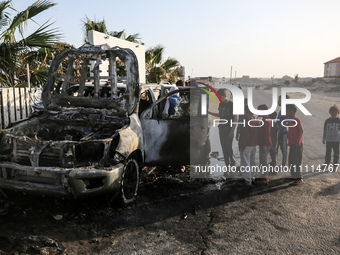 Palestinians are standing next to a vehicle in Deir Al-Balah, in the central Gaza Strip, on April 2, 2024, where employees from the World Ce...