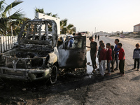 Palestinians are standing next to a vehicle in Deir Al-Balah, in the central Gaza Strip, on April 2, 2024, where employees from the World Ce...