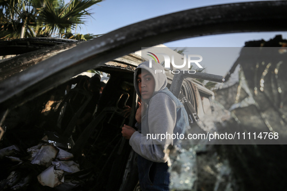 Palestinians are standing next to a vehicle in Deir Al-Balah, in the central Gaza Strip, on April 2, 2024, where employees from the World Ce...