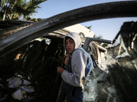 Palestinians are standing next to a vehicle in Deir Al-Balah, in the central Gaza Strip, on April 2, 2024, where employees from the World Ce...