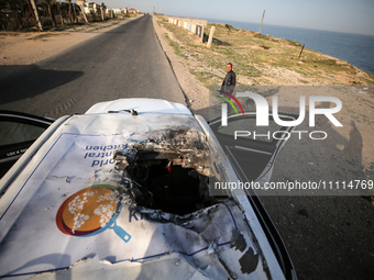 Palestinians are standing next to a vehicle in Deir Al-Balah, in the central Gaza Strip, on April 2, 2024, where employees from the World Ce...