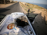 Palestinians are standing next to a vehicle in Deir Al-Balah, in the central Gaza Strip, on April 2, 2024, where employees from the World Ce...