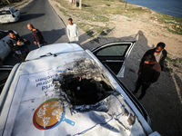 Palestinians are standing next to a vehicle in Deir Al-Balah, in the central Gaza Strip, on April 2, 2024, where employees from the World Ce...