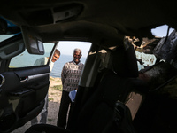 Palestinians are standing next to a vehicle in Deir Al-Balah, in the central Gaza Strip, on April 2, 2024, where employees from the World Ce...