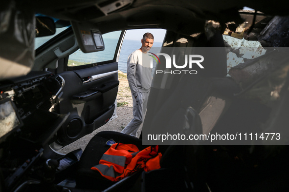 Palestinians are standing next to a vehicle in Deir Al-Balah, in the central Gaza Strip, on April 2, 2024, where employees from the World Ce...