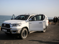 Palestinians are standing next to a vehicle in Deir Al-Balah, in the central Gaza Strip, on April 2, 2024, where employees from the World Ce...