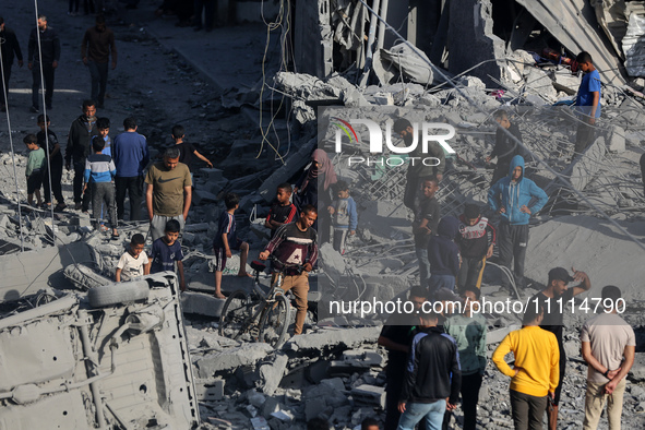 Palestinians are inspecting the damage in the rubble of the Al-Bashir mosque following Israeli bombardment in Deir al-Balah, central Gaza St...
