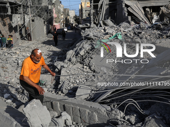 Palestinians are inspecting the damage in the rubble of the Al-Bashir mosque following Israeli bombardment in Deir al-Balah, central Gaza St...