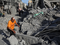 Palestinians are inspecting the damage in the rubble of the Al-Bashir mosque following Israeli bombardment in Deir al-Balah, central Gaza St...