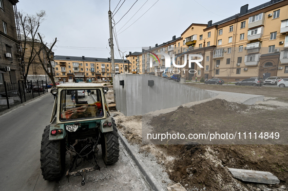 A tractor is working near a new modular underground bomb shelter, designed to accommodate 100 people, which is under construction in the yar...