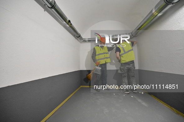 Workers are building a new modular underground bomb shelter designed for 100 people in the yard of a five-story residential building that wa...
