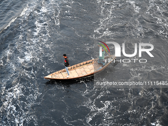 People in Bangladesh are crossing by boat over the pitch-black waters of the polluted Buriganga River in Dhaka, Bangladesh, on April 2, 2024...