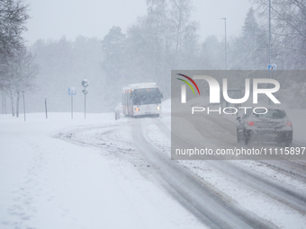 A bus is traveling on a road during a snowfall in Linkoping, Sweden, on April 2, 2024. (