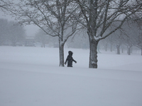 A man is walking along a road during a snowfall in Linkoping, Sweden, on April 2, 2024. (