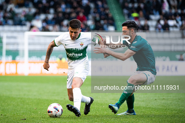 Nicolas Fernandez (L) of Elche CF is fighting for the ball with Jesus Bernal (R) of Racing de Ferrol during the LaLiga Hypermotion match bet...