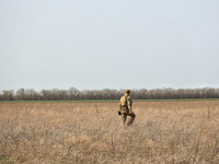 A serviceman is using a metal detector during the field tests of the MinesEye unmanned system for the detection of mines and explosive devic...