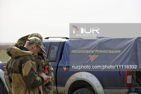 Servicemen are standing next to a car during the field tests of the MinesEye unmanned system for the detection of mines and explosive device...