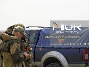 Servicemen are standing next to a car during the field tests of the MinesEye unmanned system for the detection of mines and explosive device...