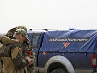 Servicemen are standing next to a car during the field tests of the MinesEye unmanned system for the detection of mines and explosive device...