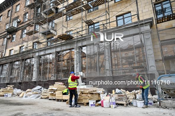 Workers are restoring an architectural monument, a five-story building that has been partially destroyed by a Russian missile attack, in Zap...