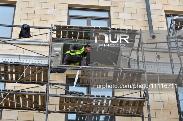 A worker is restoring an architectural monument, a five-story building that has been partially destroyed by a Russian missile attack, in Zap...