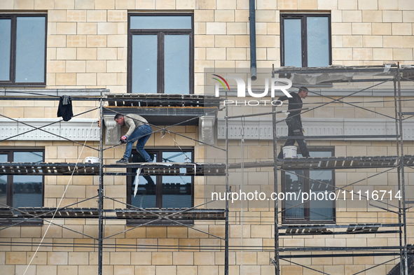 Workers are restoring an architectural monument, a five-story building that has been partially destroyed by a Russian missile attack, in Zap...