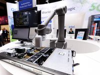 A robotic arm equipped with a surveillance camera is demonstrating its quality control process to detect imperfections at Intel's pavilion d...