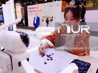 A woman is wearing traditional Chinese clothing and is playing Go with SenseRobot Go, a robot designed by SenseTime to play board games like...