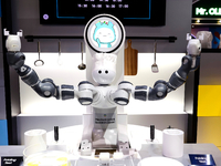 A robot with two arms is performing a MIL-STD-810G test on a Samsung Galaxy Z Flip 5 at the Samsung Display pavilion during the Mobile World...