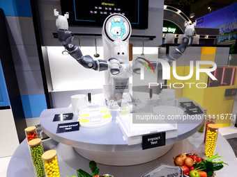 A robot with two arms is performing a MIL-STD-810G test on a Samsung Galaxy Z Flip 5 at the Samsung Display pavilion during the Mobile World...