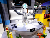 A robot with two arms is performing a MIL-STD-810G test on a Samsung Galaxy Z Flip 5 at the Samsung Display pavilion during the Mobile World...