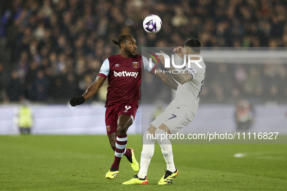 Michail Antonio of West Ham United is battling with Pedro Porro of Tottenham Hotspur for the ball during the Premier League match between We...